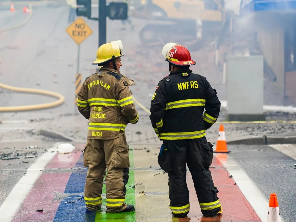 火災現場を見守る2人の消防士の写真